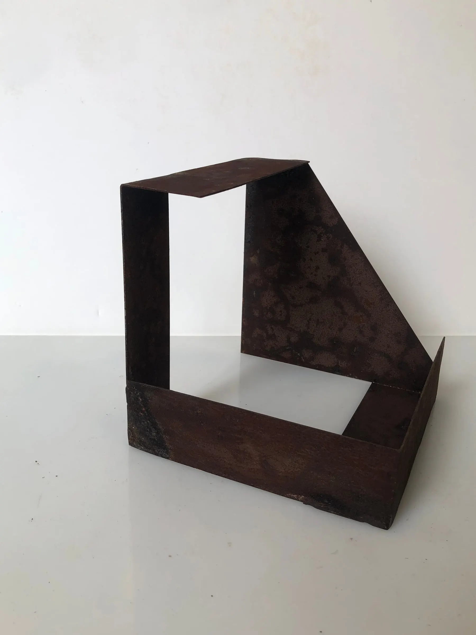 Escultura d'acer oxidat sobre fons blanc