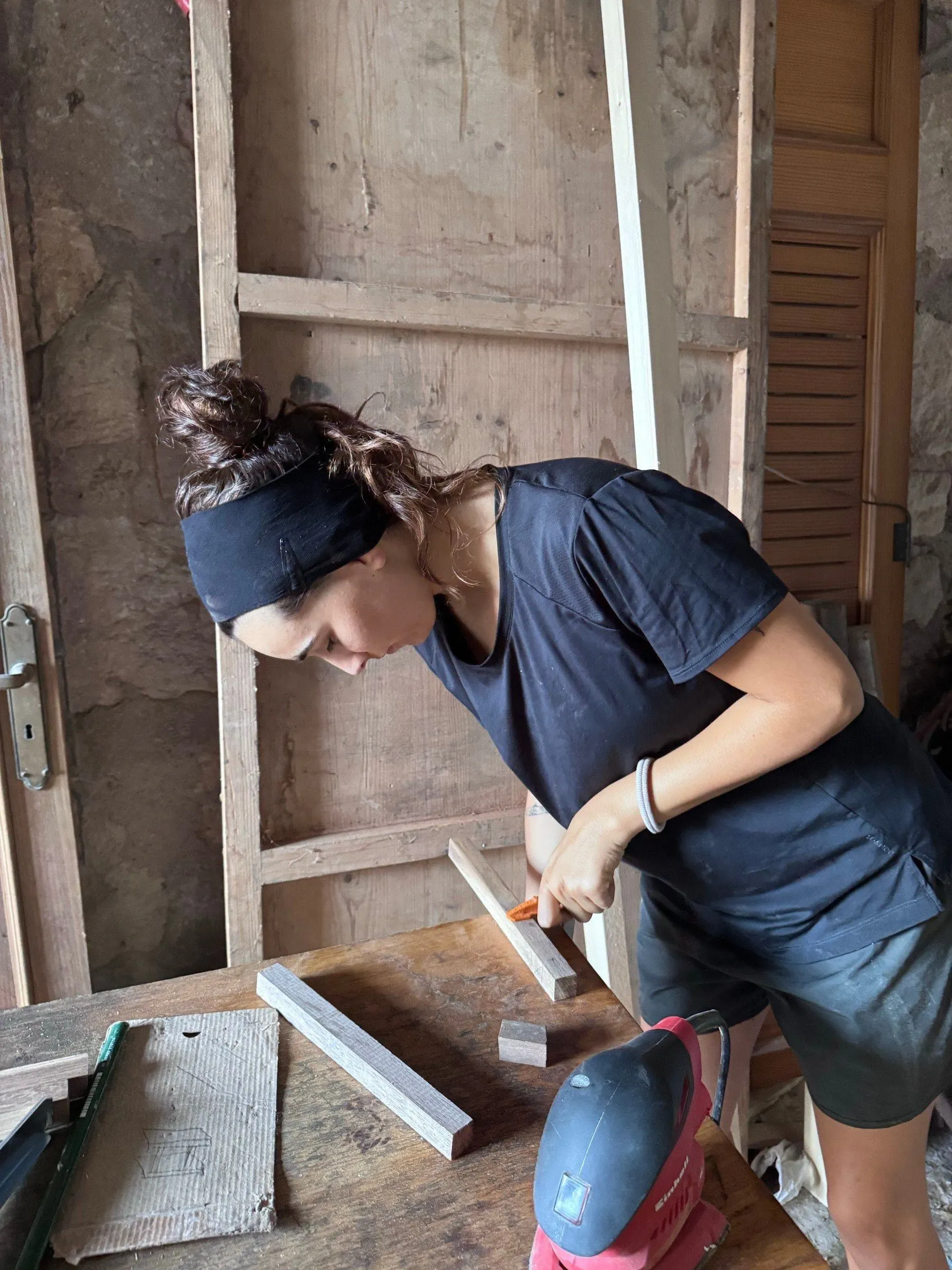 Marina treballant una peça de fusta al taller